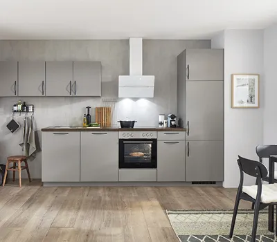 Moderne Küchenzeile in elegantem Grau mit Holzfußboden und weißen Wänden, ausgestattet mit Backofen, Dunstabzugshaube und funktionaler Arbeitsfläche, ideal für zeitloses urbanes Wohnen.